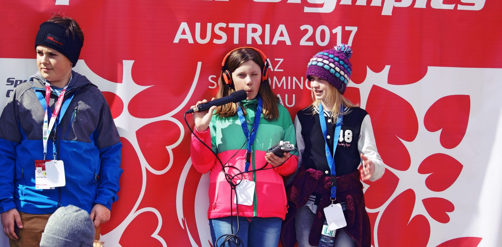 Jugendliche posieren vor dem Special Olympics Plakat